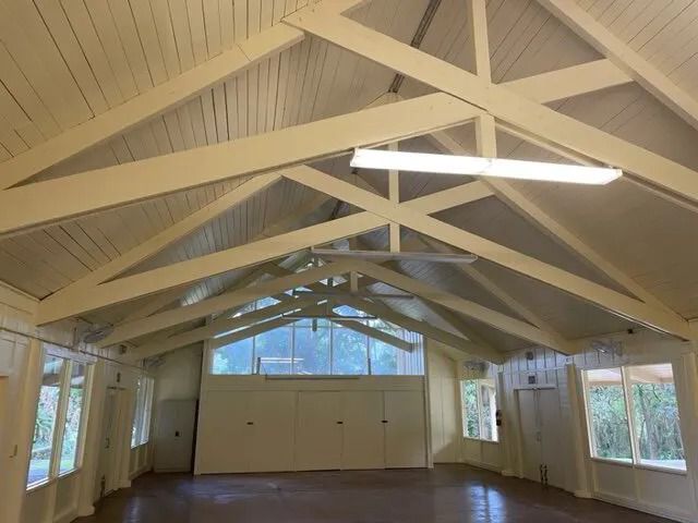 Hall interior with cream walls and painted timber trusses under a white ceiling