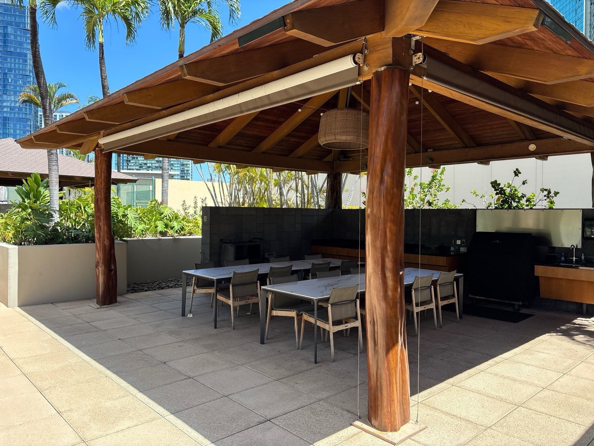 Timber barbecue pavilion beside a Kakaʻako high-rise
