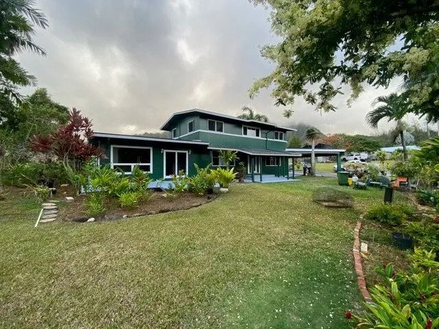 The same home painted deep green with white window trim