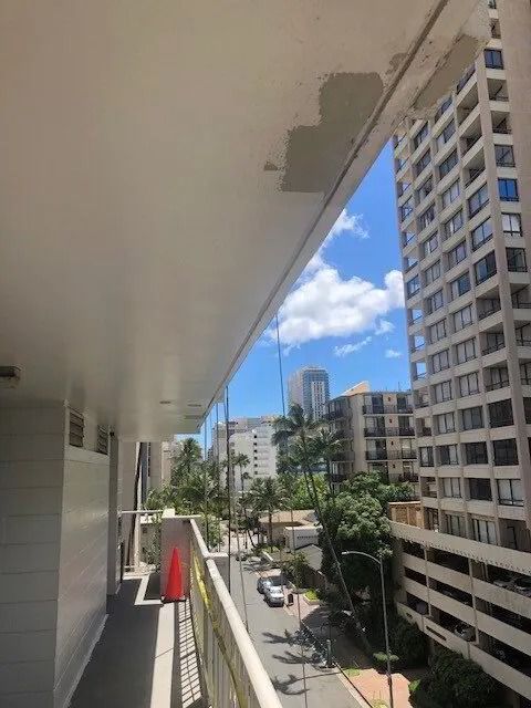 The same walkway ceiling patched smooth and painted white, the street far below