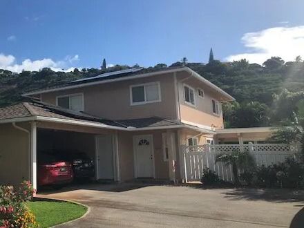 The same two-story home painted peach with white trim
