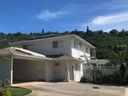Front of a white two-story home with a carport and a curving driveway