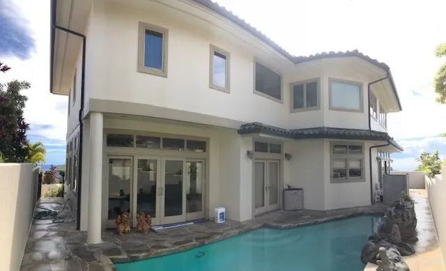 The same home finished in pale cream behind its uncovered pool