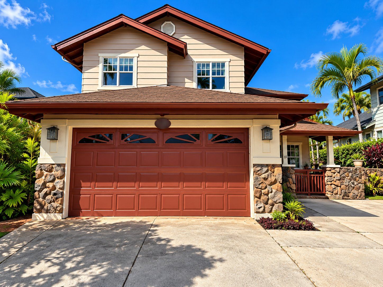 Two-story Kapolei home in beige siding with red-brown trim, a matching garage door and stone pillars